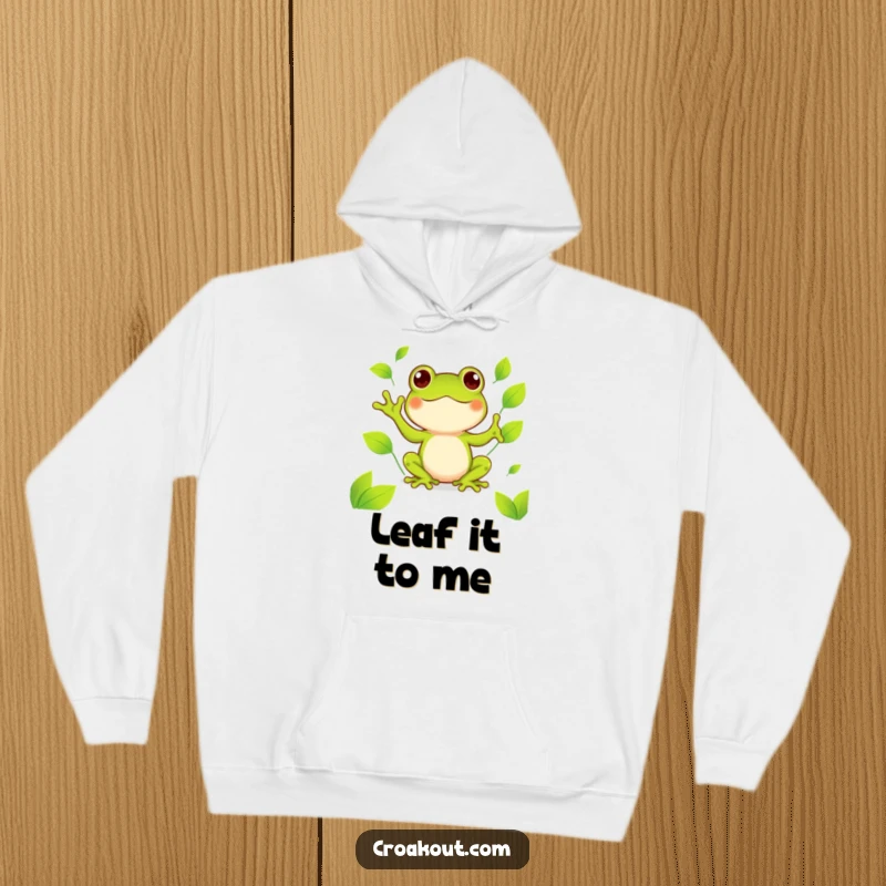 Funny kawaii frog hoodie depicting a cute amphibian happily juggling bright green leaves, a cozy and cheerful design.